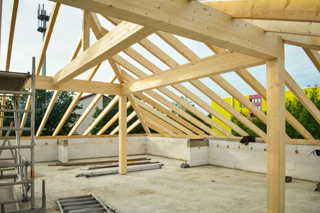 Wooden roof structure in progress with open sky view, ideal for construction themes.